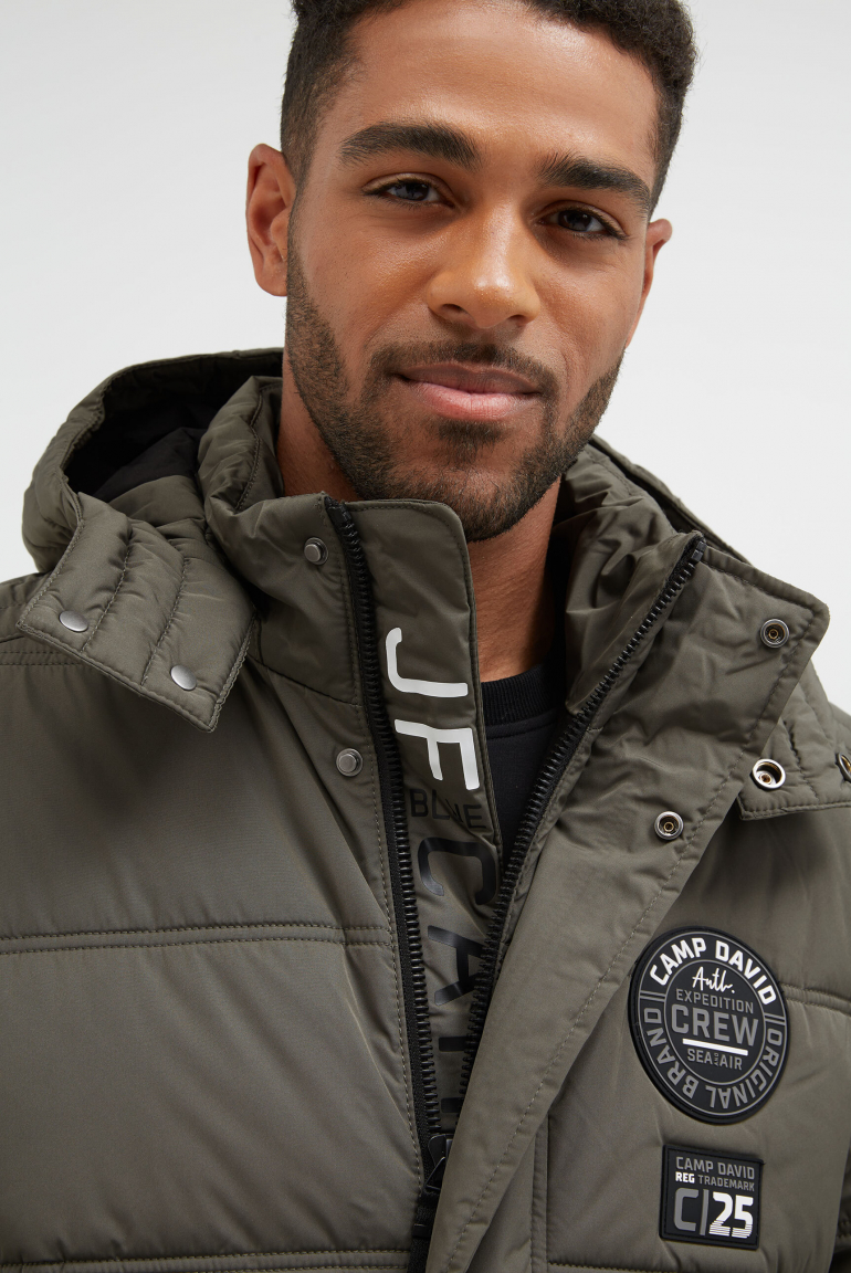 Dlouhá prošívaná bunda s kapucí a artworkem na zádech