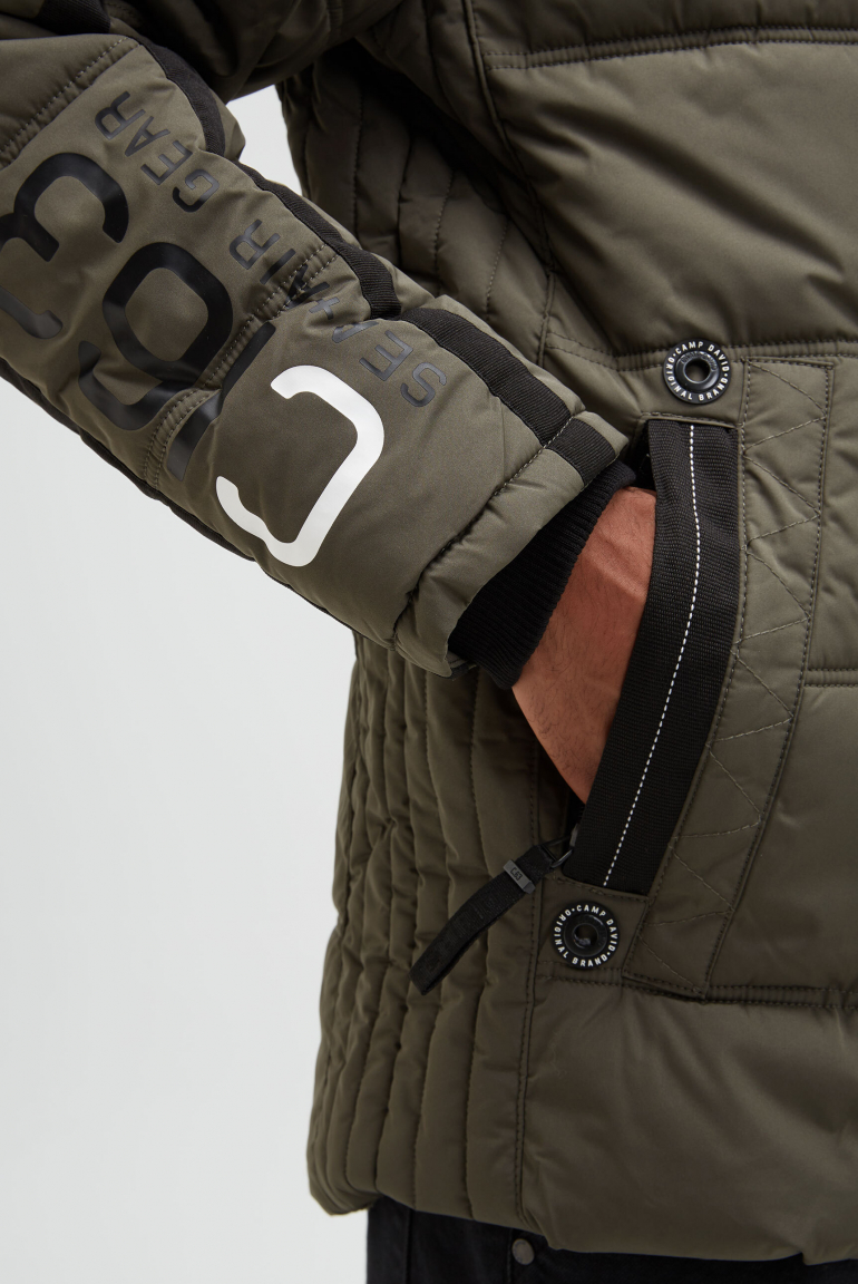 Dlouhá prošívaná bunda s kapucí a artworkem na zádech