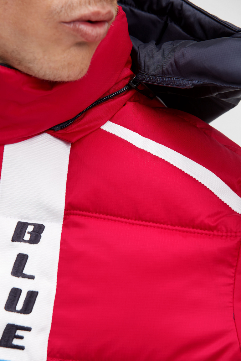 Dlouhá prošívaná bunda s pásky, nášivkami a kapucí